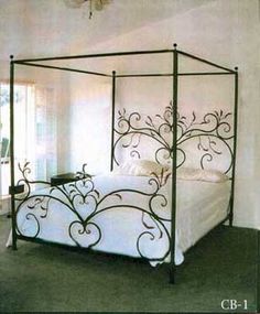 an iron bed frame with white sheets and pillows