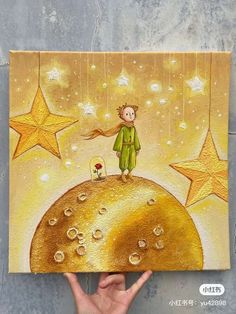 a person holding up a painting on top of a yellow moon with stars in the background