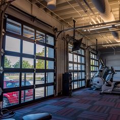 an empty gym with exercise equipment and windows