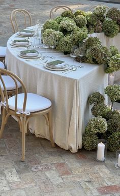 the table is set with white plates and silverware