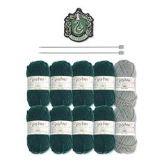 six skeins of yarn in green and grey colors with the knitting needle next to them