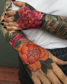 a woman with tattoos on her arms and arm, both holding onto each other's hands