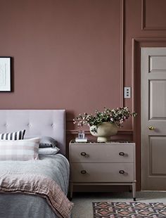 a bedroom with brown walls and white furniture