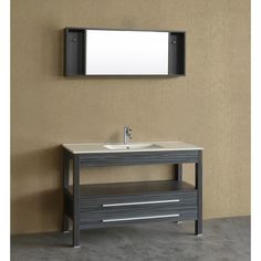 a bathroom vanity with a mirror above it next to a wall mounted faucet