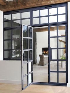 an open door leading to a living room with a fire place in the fireplace behind it