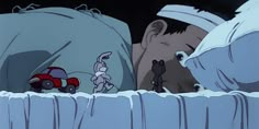 an animated image of a man and woman sleeping in bed with a toy car behind them