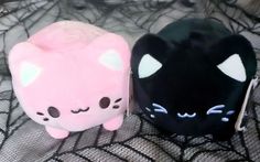 two black and pink stuffed animals sitting on top of a net covered bed with white sheets