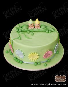 there is a green cake with two babies on it