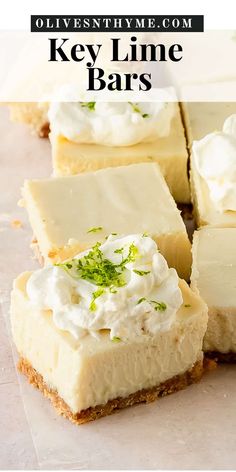 key lime bars with whipped cream and green garnish on top, sitting on parchment paper