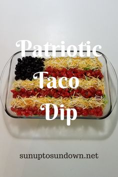 a patriotic taco dip in a glass dish with the words patriotic on it and an american flag made out of shredded cheese