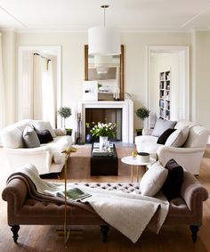 a living room filled with furniture and a fire place in the middle of a room