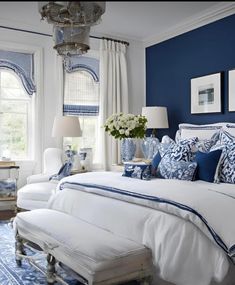 a bedroom with blue walls and white furniture