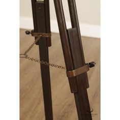 a wooden easel with chains attached to it on top of a hard wood floor