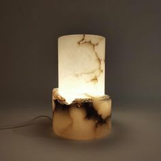 a table lamp made out of marble with a white light on the top and bottom