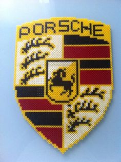 a close up of a cross stitched badge on a blue surface with the words porsche