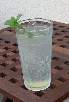 a glass filled with water sitting on top of a wooden table