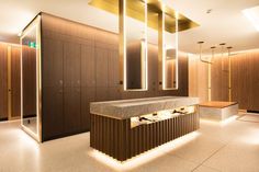 a large bathroom with wooden cabinets and marble counter top, lighted by recessed lights