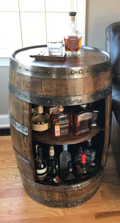 a wooden barrel table with liquor bottles on it