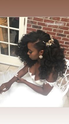 a woman sitting on top of a white chair wearing a dress and flower in her hair