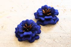 two blue flowers sitting on top of a wooden table