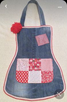 an apron made out of old jeans with red and white patchwork on the front