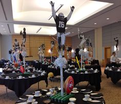 a football player is standing on top of a table with plates and cups in front of him