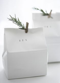 two white boxes with small plants in them sitting on top of each other's sides