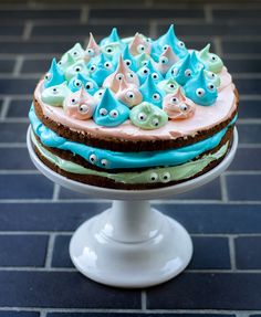 there is a cake with blue and green frosting on the top that looks like monsters