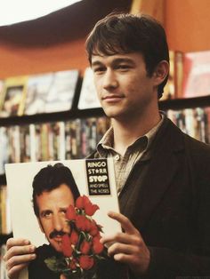 a man holding up a book with roses on it