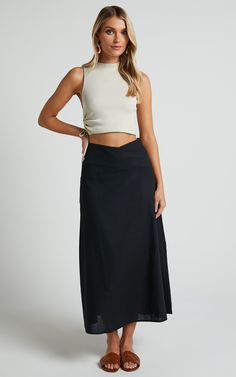 Get ready to turn heads in this flirty and playful Sundry Midi Skirt! With its linen look fabric and high-waisted design, this A-line skirt is perfect for casual days out or dressed up for a night on the town. The cross-front detail adds a touch of sassiness to your outfit, while the black color ensures versatility. Whether you pair it with a crop top or a cozy sweater, this midi skirt is sure to become your new go-to piece for effortless style. So why wait? Embrace your inner fashionista and st Chic Flared Maxi Skirt For Beach, Flattering Midi Skirt For Summer, Fitted Lined Wrap Skirt For Day Out, Fitted Flared Wrap Skirt For Beach, Fitted Linen Maxi Skirt For The Beach, Chic Solid Color Maxi Skirt With Lining, Chic Asymmetrical Gathered Maxi Skirt, Chic Gathered Skort, Chic Lined Maxi Skirt