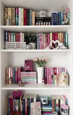 the shelves are filled with books and flowers in vases on top of each shelf