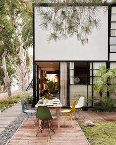 an outdoor dining area with tables and chairs in front of a building that has trees on it