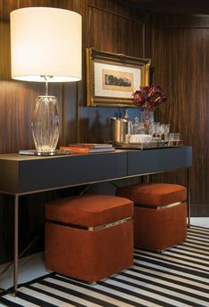 a table with two stools and a lamp on top of it in a room