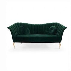 a green velvet couch sitting on top of a white floor