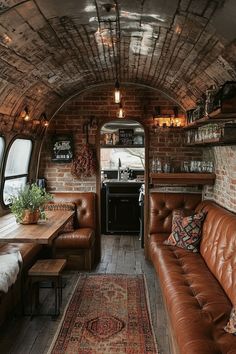 the interior of an airstream with leather couches, tables and rugs on the floor