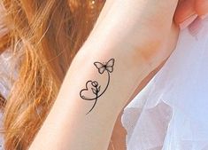 a woman's arm with a tattoo on it that has a butterfly and heart