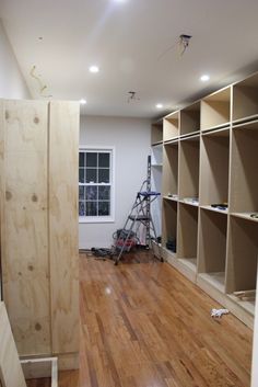 an unfinished room with wood floors and shelving