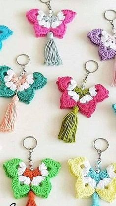 crocheted keychains with tassels are arranged on a white surface