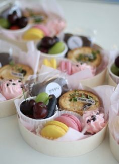 several small containers filled with assorted pastries on top of a white countertop