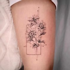 a woman's thigh with sunflowers in a vase tattoo on the side