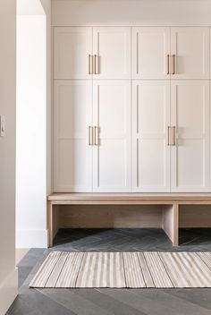 a room with white cupboards and carpeted flooring in front of the wall