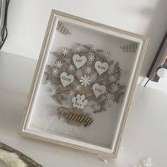 a family card with hearts and flowers in a frame on a table next to a vase