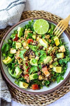 a salad with avocado, lettuce, tomatoes and other ingredients in a bowl