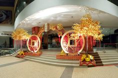 the entrance to a shopping mall decorated in gold and red with golden decorations on display