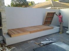 a man standing next to a wooden bench in the middle of a building under construction