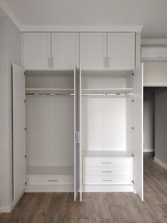 an empty room with white closets and wood flooring on the walls, along with wooden floors