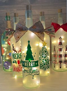 lighted bottles with christmas trees and lights on them