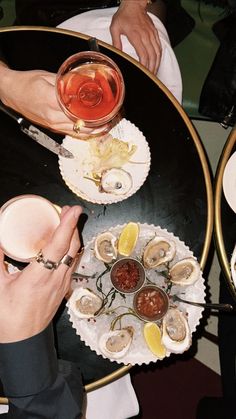 two people sitting at a table with food and drinks