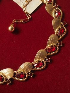 levate your style with the Ruby-Red Elegance Necklace, a stunning accessory designed to capture attention. This exquisite piece features a striking combination of ruby-red stones and golden elements, elegantly arranged in a unique and contemporary pattern. Perfect for adding a touch of sophistication and luxury to any outfit, whether for a special occasion or daily wear. Details: Material: Brass with gold plating Length: 33 cm with an additional 9 cm extension chain Weight: Approximately 46 g Care Instructions: To maintain the beauty and longevity of your necklace, avoid direct contact with water, perfumes, or chemicals. Opulent Jeweled Jewelry For Formal Occasions, Opulent Jeweled Formal Jewelry, Vintage Ruby Necklace For Formal Occasions, Elegant Jeweled Gold-plated Necklaces, Elegant Jeweled Gold Plated Necklaces, Luxury Red Necklaces For Formal Occasions, Elegant Yellow Gold Garnet Necklace, Vintage Ruby Evening Jewelry, Elegant Party Necklaces With Stone Setting