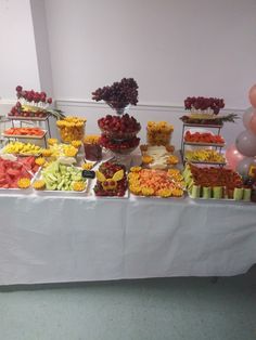 an assortment of fruits and vegetables displayed on a table in a banquet or wedding reception